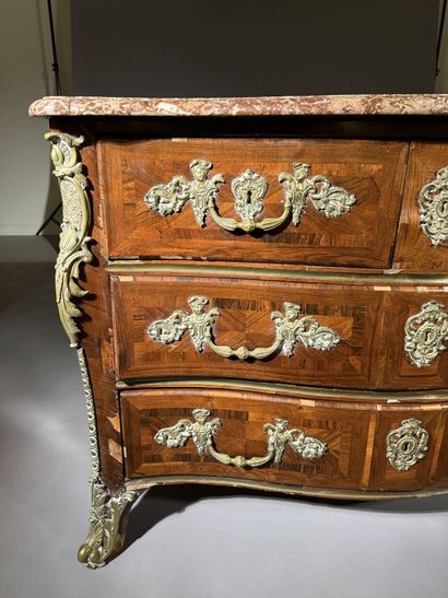 A rosewood chest of drawers with a curvilinear...