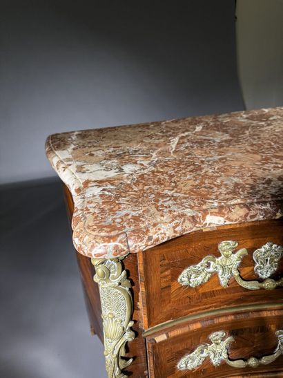 A rosewood chest of drawers with a curvilinear...