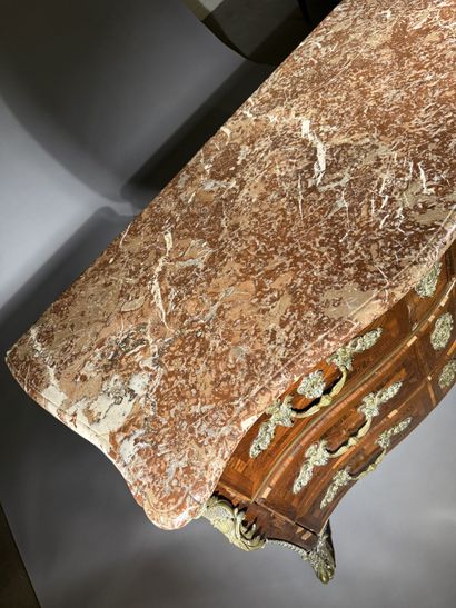 A rosewood chest of drawers with a curvilinear...