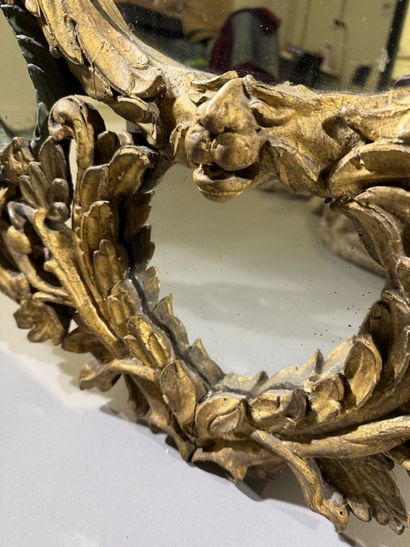 Large oval mirror with carved, gilded, and...