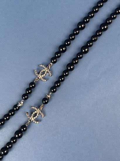 CHANEL 
Sautoir en perles noires entrecoupées...