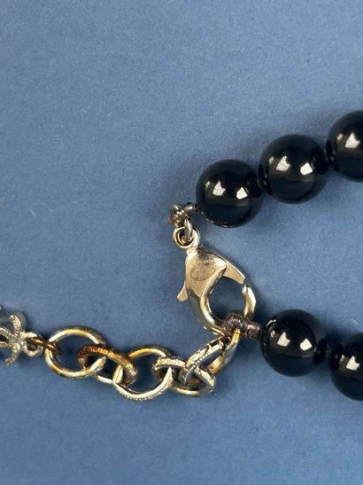 CHANEL 
Sautoir en perles noires entrecoupées...