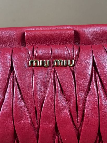 MIU MIU 
Sac pochette en cuir rouge plissé...