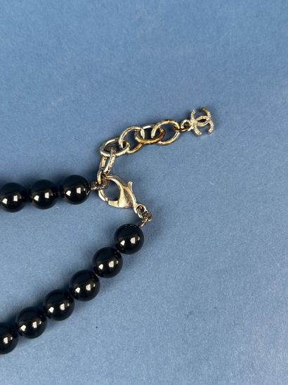 CHANEL 
Sautoir en perles noires entrecoupées...