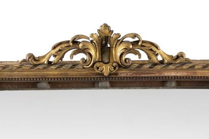 Grand miroir en bois doré à décor de feuillages,...