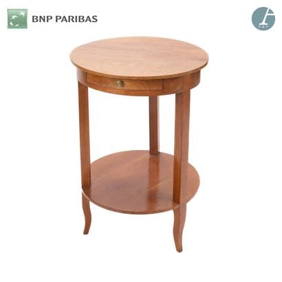 Un guéridon en bois naturel ouvrant par un...