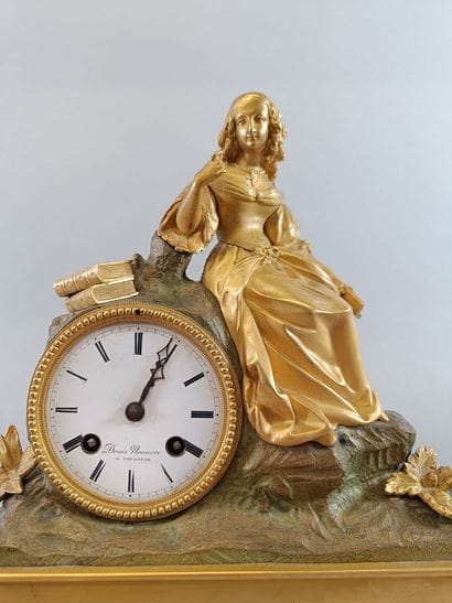 Romantic-style bronze clock topped by a female...