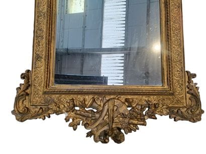 Large wooden mirror with gilded stucco 
featuring...