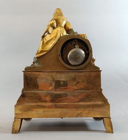Romantic-style bronze clock topped by a female...