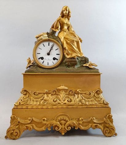 Romantic-style bronze clock topped by a female...