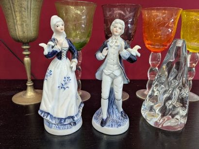 Set of glasses accompanied by two small figurines...