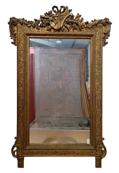 Large wooden mirror with gilded stucco 
featuring...