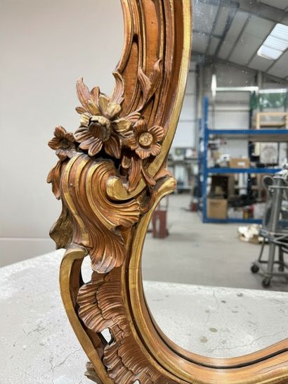 Miroir biseauté en bois et stuc doré à décor...