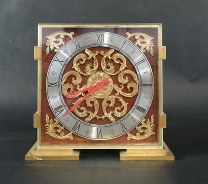 Horloge carré en métal doré. Numérotée sous...