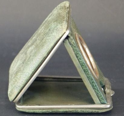 Un réveil de voyage en tissu et cuir vert....