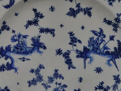 MOUSTIER. Plat en faïence à décor en camaïeu...