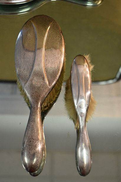 A silver toiletry set with three brushes...