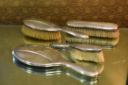 A silver toiletry set with three brushes...