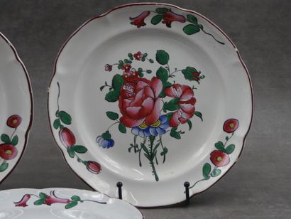 Trois assiettes en faïence décor floral en...