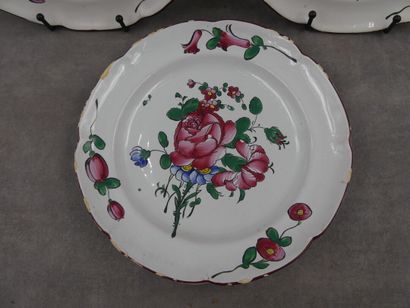Trois assiettes en faïence décor floral en...