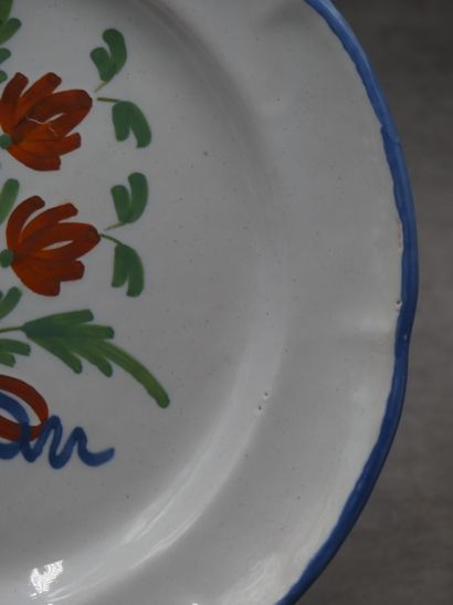 Assiette en faïence au bouquet, bords bleu....