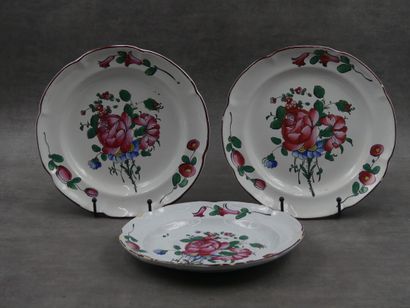 Trois assiettes en faïence décor floral en...