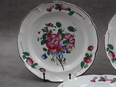 Trois assiettes en faïence décor floral en...