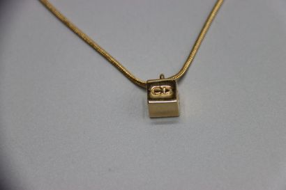 CHRISTIAN DIOR. Collier métal doré pendentif...
