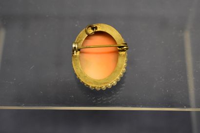 Une broche/pendentif camée entouré de perles....