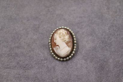 Une broche/pendentif camée entouré de perles....