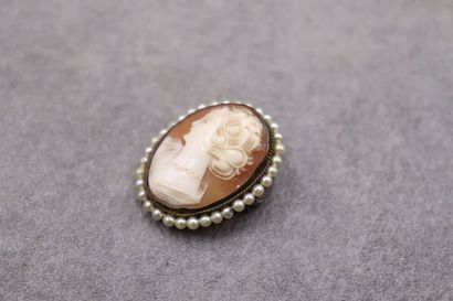 Une broche/pendentif camée entouré de perles....