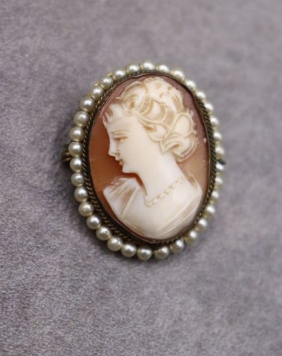 Une broche/pendentif camée entouré de perles....