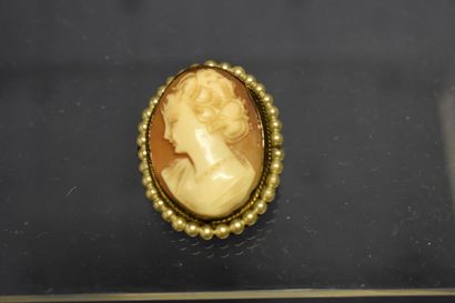 Une broche/pendentif camée entouré de perles....