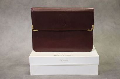 CARTIER. Pochette en cuir bordeaux et métal...