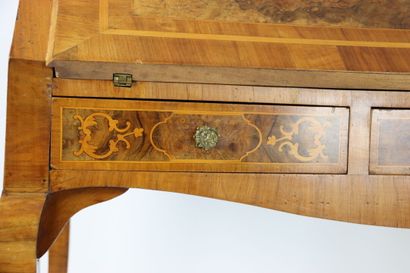 Un bureau de pente en noyer mouluré et sculpté,...