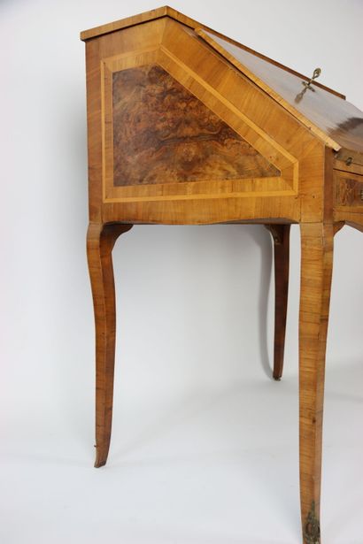 Un bureau de pente en noyer mouluré et sculpté,...