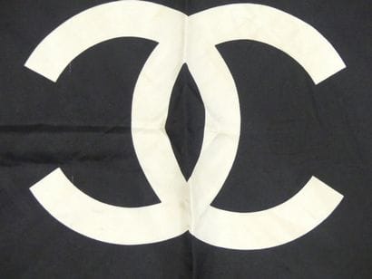 CHANEL. Silk square with gold chain decoration...