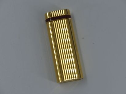 CARTIER. Lighter in gilded metal and red...