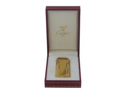 CARTIER. Lighter in gilded metal and red...