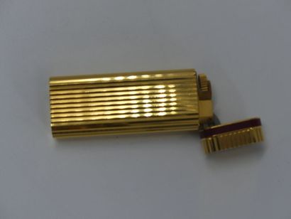 CARTIER. Lighter in gilded metal and red...