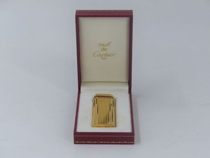 CARTIER. Lighter in gilded metal and red...
