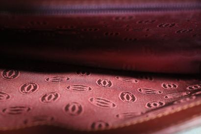 CARTIER. Pochette en cuir bordeaux et métal...