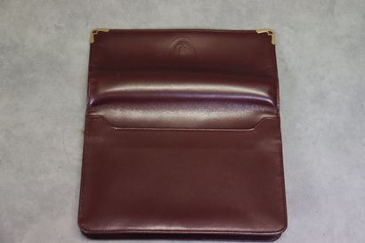 CARTIER. Pochette en cuir bordeaux et métal...