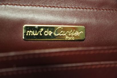 CARTIER. Pochette en cuir bordeaux et métal...