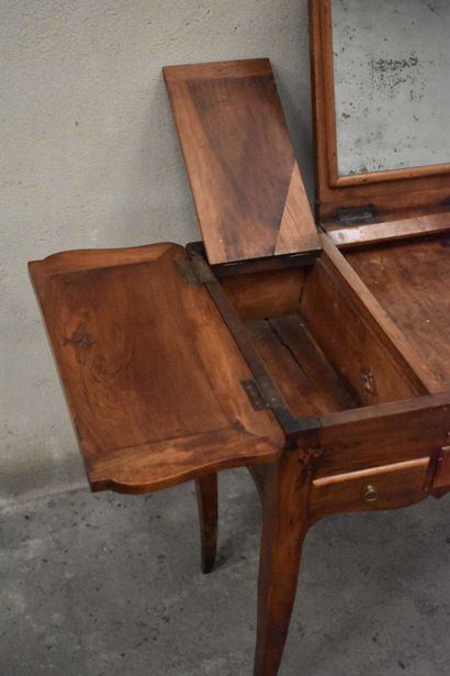 Une coiffeuse en bois patiné ouvrant par...