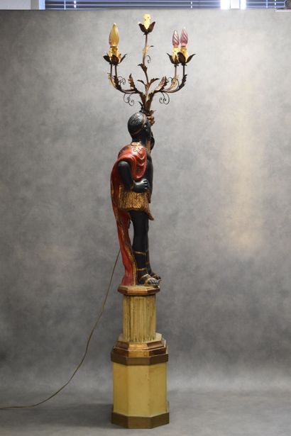 Man with a cape carrying a torch in carved...