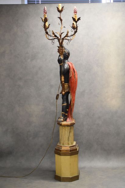 Man with a cape carrying a torch in carved...