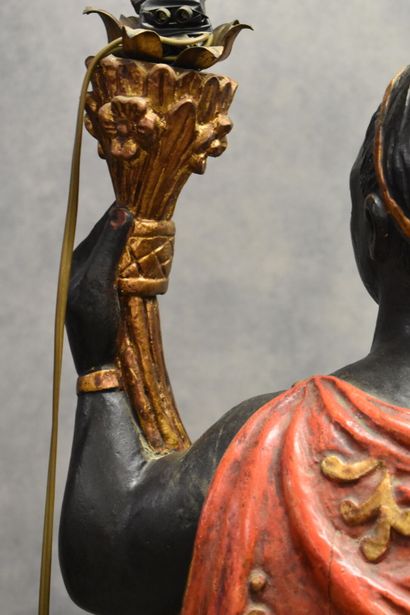 Man with a cape carrying a torch in carved...