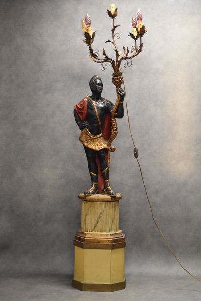Man with a cape carrying a torch in carved...