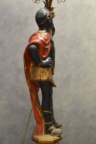 Man with a cape carrying a torch in carved...
